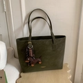 Detail of olive green suede tote bag featuring a cute dachshund leather charm and gold logo - Green with Pendant