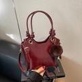 Borsa a secchiello vintage bordeaux in finta pelle lucida con pompon e tracolla fine - Con Ciondolo / Borgogna