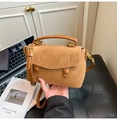 Detail of vintage brown suede leather handbag with wavy flap and golden metal hardware - Brown