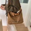 Large brown canvas tote bag with Pantor & Stories logo shown on shoulder in daily use - Brown