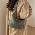 Detail of adjustable metal buckle and canvas texture on olive green crescent bag - Green