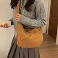 Mustard yellow canvas dumpling crossbody bag worn by model for casual style - Brown