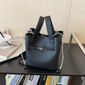 Dettaglio borsa a secchiello in pelle nera con chiusura argento e lacci color crema - Nero
