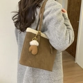 Detail of brown suede tote bag with cream faux fur trim and heart-shaped charm - Brown