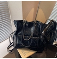 Detail of black quilted leather tote with metal chain strap and side drawstring - Black