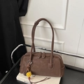 Detail der braunen Leder-Bowling-Tasche mit Litschi-Muster und dekorativem Bommel-Anhänger - Mit Anhänger / Braun