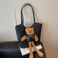 Black tote bag with a cute brown plush bear charm and 'NOISY TEDDY' blue scarf detail - Black