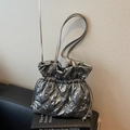 Silver quilted bucket bag with drawstring closure and metallic finish shoulder strap - Gray