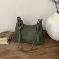 Primer plano de bolso de cuero verde oscuro mate con hebilla dorada y logotipo - Verde
