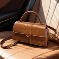Brown retro small square handbag with adjustable strap on a leather car seat - Brown