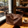 Retro dunkelbraune große Shopper Tasche mit verstellbarem Gurt auf Holz Tisch - Braun