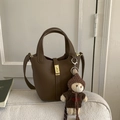 Gros plan d'un sac seau marron avec un ourson en peluche sur un canapé en tissu doux - Avec Pendentif / Marron