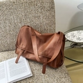 Detailed view of the soft brown leather texture and flap design on a vintage messenger bag - Cinnamon Brown