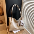 Large beige faux leather tote bag with a grey plush bunny charm in natural sunlight - Beige With Charm