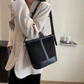 Sac seau en daim noir avec garniture en cuir et bandoulière réglable porté par le modèle - Noir