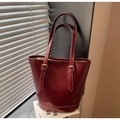 Detail of dark red oil-wax leather tote with adjustable gold buckles and bucket shape - Burgundy