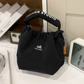 Schwarze Canvas-Tragetasche im Kordelzug-Stil mit Logo-Riemen in Lifestyle-Kulisse - Schwarz