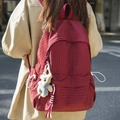 Red plaid canvas backpack with white bear keychain shown on person outdoors - Red with Pendant