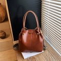 Vintage brown bucket bag with shiny faux leather finish and geometric woven shoulder strap - Brown