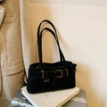 Retro black matte baguette shoulder bag with gold metal buckle on a travel setting - Black