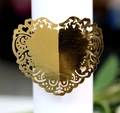 Macro shot of laser-cut gold mirror heart-shaped napkin ring with delicate hollow pattern - Reflective Gold