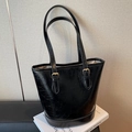 Minimalist black bucket bag in cracked-texture leather with gold buckle detail - Black