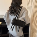 Minimalist black cylinder shoulder bag in matte suede finish with silver buckle - Black