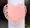 Makroansicht von rosa Herz-Serviettenringen mit Laser-Cut-Spitzenmuster und Perlglanz-Oberfläche - Rosa