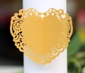 Makro-Detail von lasergeschnittenem Herz-Serviettenring aus gelbem Papier für Hochzeiten - Gold