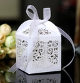 Close-up of laser-cut European pattern on white wedding favor box with ribbon bow - White