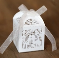 Close-up of laser-cut white wedding favor box with romantic couple silhouette and ribbon - White