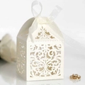 Close-up of laser-cut vine patterns on white wedding favor box with a satin ribbon - Ivory
