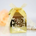 Vue macro boîte à dragées dorée ajourée avec rose et élégant ruban en soie jaune - Or Réfléchissant