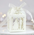 Close-up of laser-cut wedding favor box with bride and groom silhouette and white ribbon - Ivory