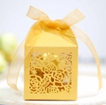 Detalle de patrones de rosas cortados con láser en caja de regalo dorada con cinta - Dorado