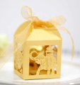 Golden laser-cut elephant wedding favor box with ribbon on a decorative white plate - Gold