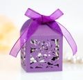Detail der lasergeschnittenen Rosenmuster auf einer violetten Hochzeitsbox mit Geschenkband - Dunkellila