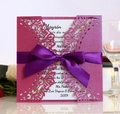 Dettaglio invito rosa tagliato al laser con motivi floreali e fiocco in nastro viola - Rosso Porpora