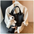 Détail d'un sac seau noir découpé au laser avec texture grainée et breloque en peluche - Noir Avec Pendentif