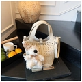 Detail of cream hollowed-out bucket bag with cute teddy bear charm on books - Beige With Charm