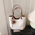 Borsa tote bianca con trama litchi, dettagli in pelle marrone e ciondolo a orso - Bianco Sporco