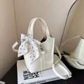 Cream white leather bucket bag with silver lock and black polka dot silk scarf detail - White