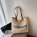 Beige canvas tote bag with blue TAOCAITU lettering and brown leather handles - Khaki