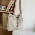 Minimalist beige nylon drawstring shoulder bag with large front pockets and adjustable strap - White