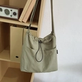 Light green nylon drawstring crossbody bucket bag with dual front pockets for casual wear - Green