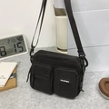 Versatile black multi-pocket canvas crossbody bag with adjustable strap and zip closure - Black