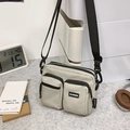 Off-white nylon crossbody bag with multi-pocket design and adjustable black strap - White