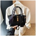 Detalle de bolso saco trenzado negro con pañuelo de pata de gallo y cierre de giro dorado - Negro
