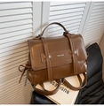 Close-up of vintage brown leather backpack featuring dual straps and branded front flap - Brown