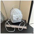 Close-up of light blue quilted mini backpack with silver chain strap and metal lock - Blue